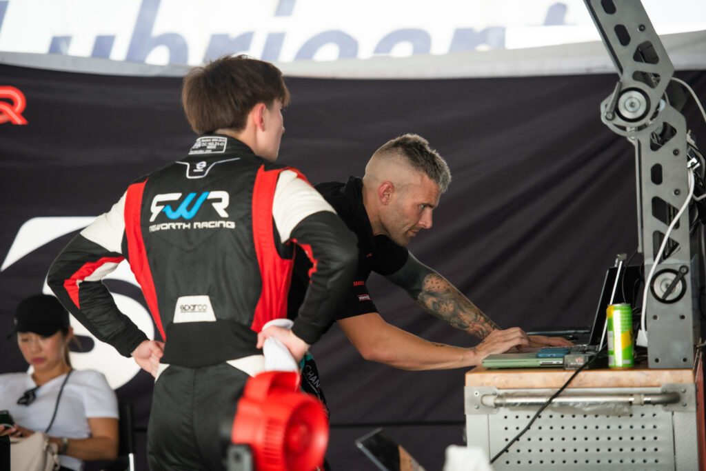 Jono Lester coaching a driver in the pit garage